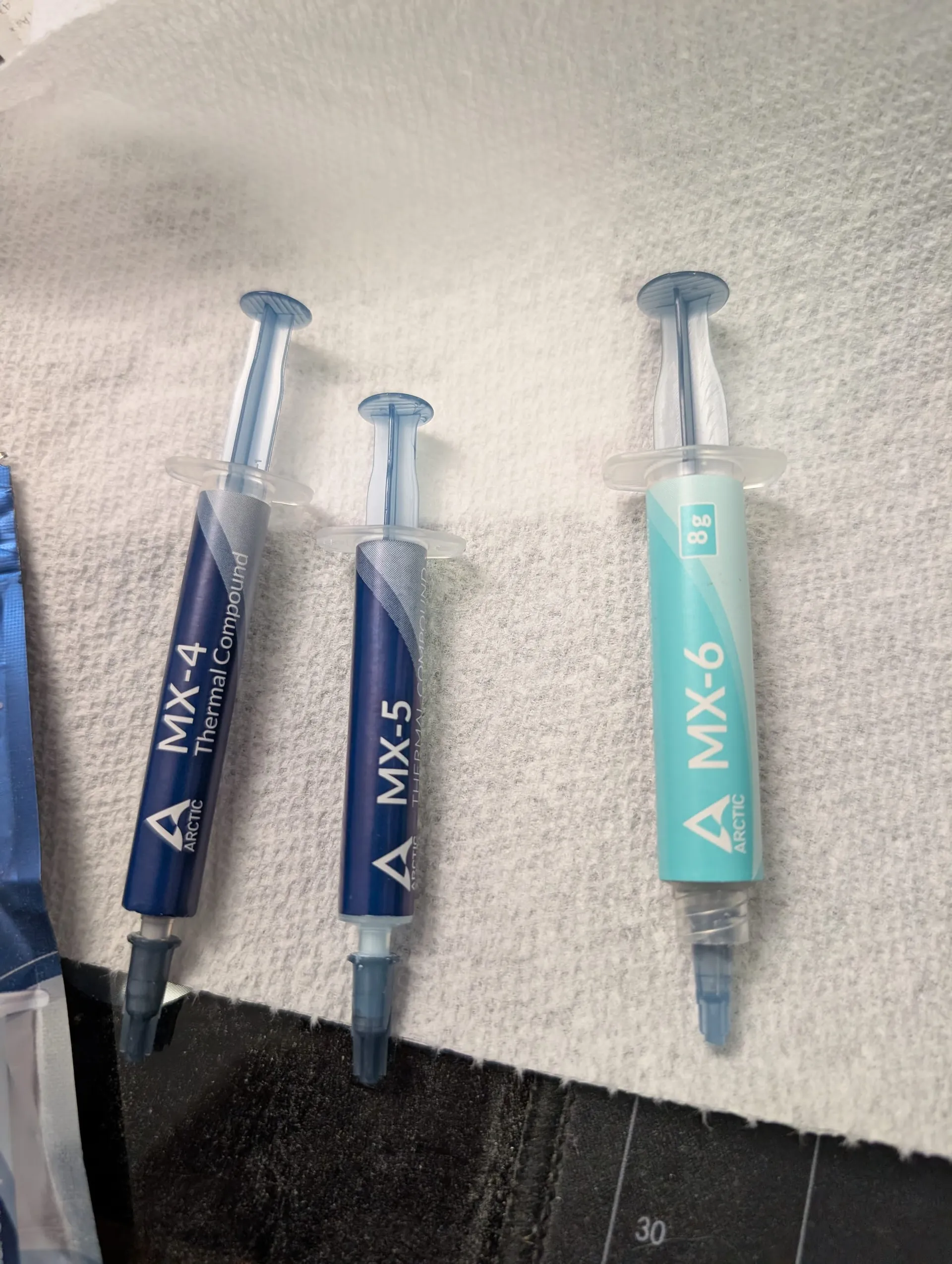 Image of 3 different generations of Arctic thermal paste, MX-4, MX-5 and MX-6.