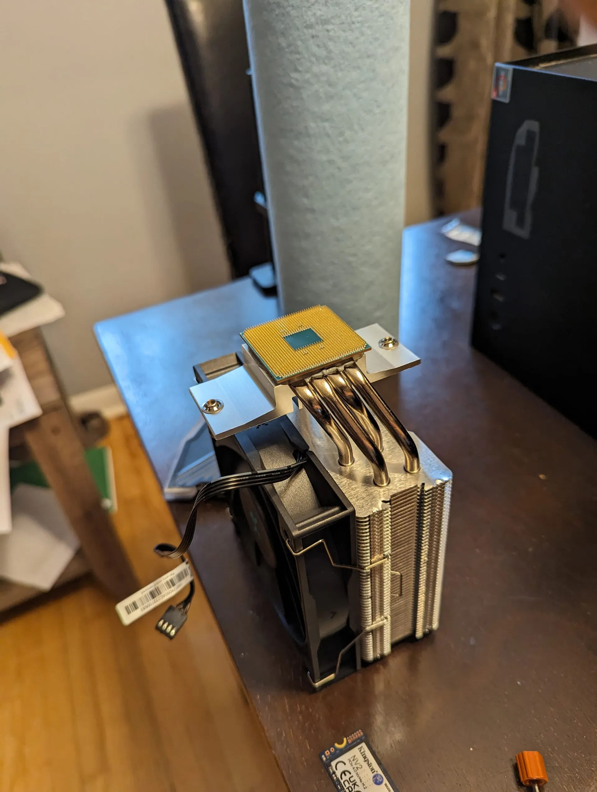 Picture of a CPU upside down, stuck to a cooling plate on a CPU cooler. I had to PRY the CPU off the thermal plate...