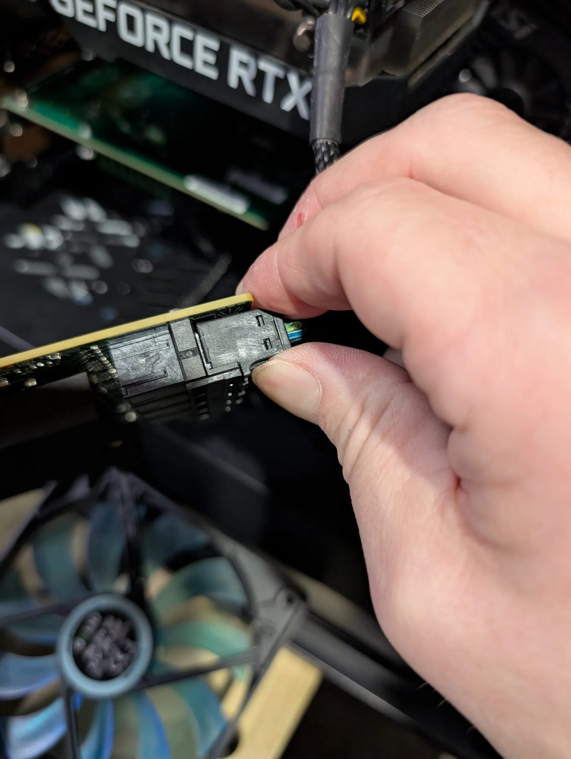 A picture of me squeezing the release tab on the HBS SAS connector to get it off the HBA card.