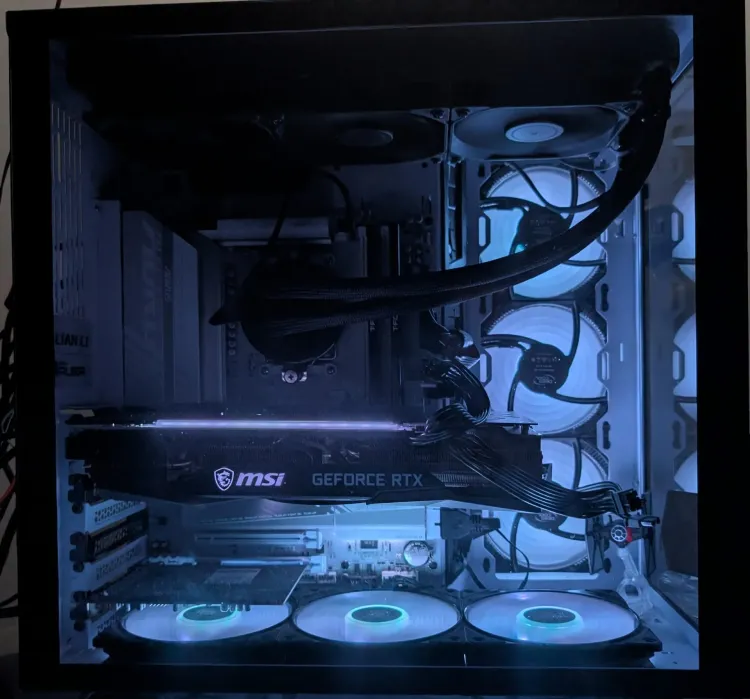 Side view of white Lian Li O11 Dynamic XL PC with black Fractal Celsius S36 AIO, MSI 3070 Ti, glowing white fans, and a TIE fighter model inside the glass panel.
