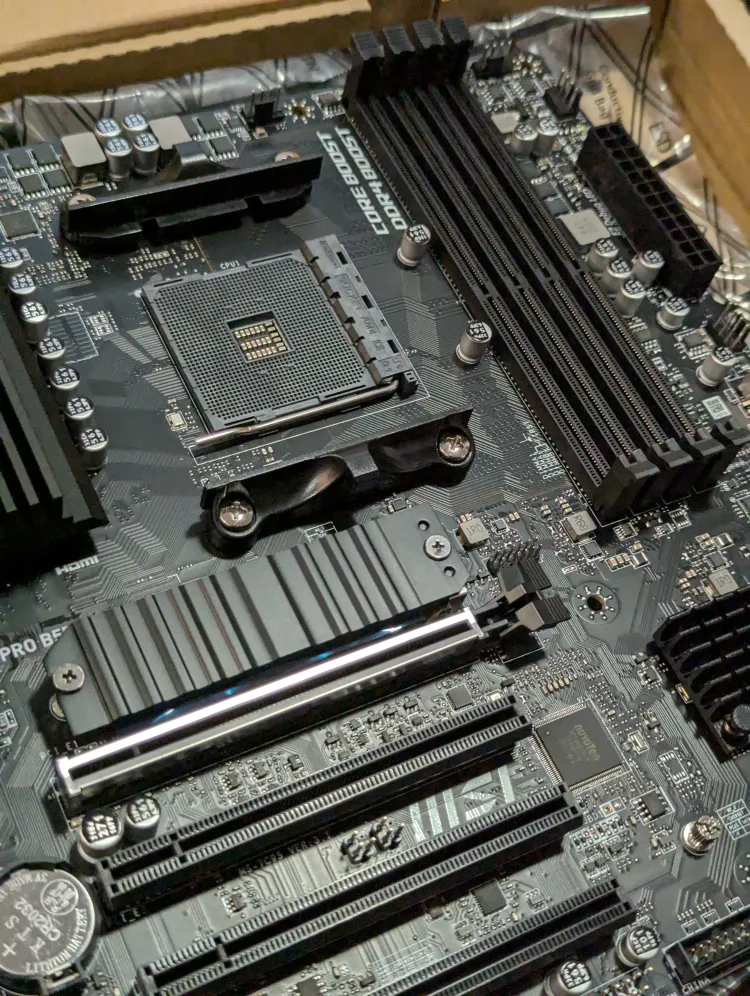 Closeup of a brand new motherboard, black, labelled MSI and is in fact, an MSI X570 Pro-A motherboard.